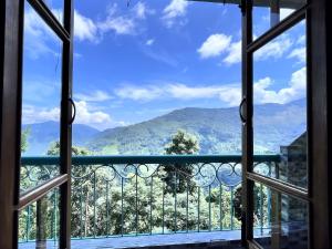 a window with a view of a mountain view at Ningma Lamu Homestay in Mangpu +4 photos