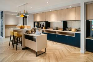 a kitchen with blue cabinets and a counter with chairs at TownePlace Suites by Marriott Seekonk in Seekonk