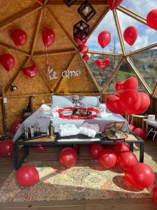 a room with red balloons and a bed in a tent at Hotel Deluxe Glamping in Guatapé