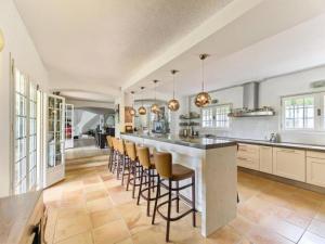 a kitchen with a large island with bar stools at Havre de paix -Élégante villa avec piscine au cœur d'un écrin de verdure in Vence