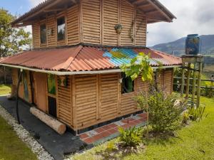 a wooden house with a copper roof at Cabaña sol de oriente in Marinilla