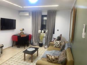 a living room with a couch and a table and a piano at Superbe appartement Khezama in La Corniche