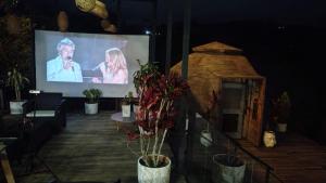 a stage with a screen with a man and a woman on it at Hotel Deluxe Glamping in Guatapé