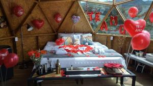 a room with a bed with red balloons and a table at Hotel Deluxe Glamping in Guatapé +5 photos