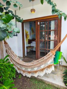 a hammock on the front porch of a house at Dona Maragô Pousada in Maragogi