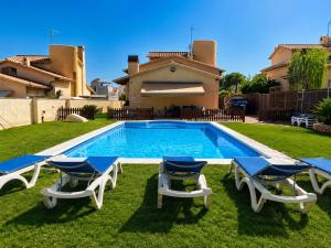 a swimming pool with chairs and a house at Villa Neus Barà, jardín y piscina privada in Roda de Bará