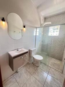 a bathroom with a toilet and a shower and a sink at Chacara Recanto Mirella in Socorro