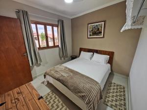 a small bedroom with a bed and a window at Cura e Conexões in Jarinu +50 photos