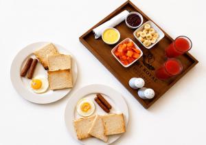 a table with two plates of breakfast foods and drinks at Port Royal Residence in Trincomalee