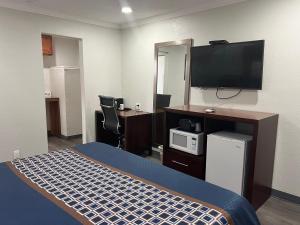 a hotel room with a bed and a flat screen tv at Golden Eagle Motel in Dorris