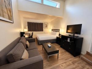 a living room with a couch and a bed and a television at H&H Motor Lodge in Idaho Springs