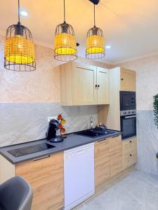 a kitchen with wooden cabinets and three hanging lights at Maison privative SPA Jacuzzi Sauna Salle de jeux in Weitbruch