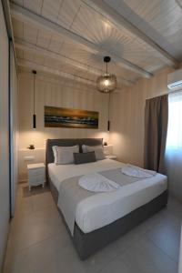 a bedroom with a large white bed with a chandelier at Horizon Hill Villa in Tinos +64 photos