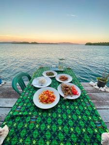 a table with plates of food on top of the water at Sunrise Raja Ampat in Besir +31 photos