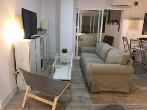 - un salon avec un canapé et une télévision dans l'établissement Apartamento Torreblanca FREE PARKING, à Fuengirola