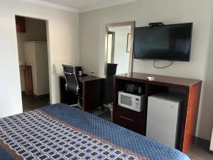 a room with a bed with a tv and a microwave at Golden Eagle Motel in Dorris