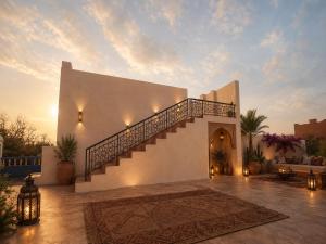 a villa with a staircase and a sunset at Ocean Wings House in Rbat