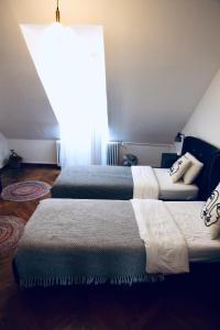 two beds in a room with a large window at The sanctuary ljubljana in Ljubljana
