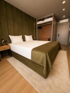 a bedroom with a large bed with a green wall at INOTEL Paços de Ferreira in Paços de Ferreira +22 photos