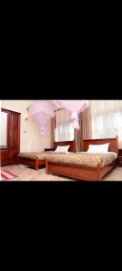a bedroom with two beds and pink lighting at Meraki Palate in Entebbe +6 photos