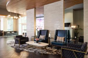 a lobby with two chairs and a table and a couch at Archer Hotel Falls Church in Fairfax