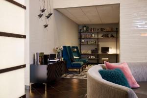 a living room with a couch and two chairs at Archer Hotel Falls Church in Fairfax