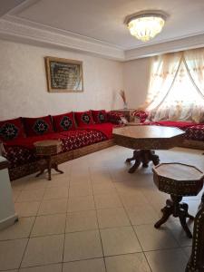 a living room with a red couch and tables at appartement 3 gare tgv in Kenitra