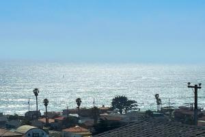 a view of the ocean with buildings and palm trees at Park Avenue Beach Life in Cayucos