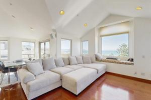 a living room with a white couch and windows at Park Avenue Beach Life in Cayucos