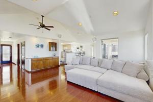 a living room with a white couch and a kitchen at Park Avenue Beach Life in Cayucos
