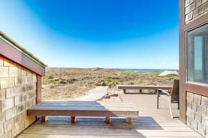 a patio with a bench and a view of the beach at Rita's-by-the-Sea in Moss Landing