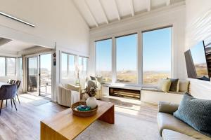 a living room with white walls and large windows at Rita's-by-the-Sea in Moss Landing