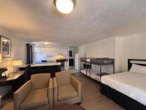 a hotel room with a bed and a kitchen and a room at H&H Motor Lodge in Idaho Springs
