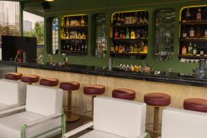 a bar with stools and a counter with liquor bottles at Roma Nueve Dos Hotel Boutique in Mexico City