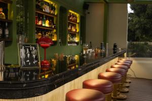 a bar with a row of stools in a room at Roma Nueve Dos Hotel Boutique in Mexico City +10 photos
