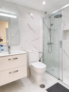 a white bathroom with a toilet and a shower at Verdi House in Torrevieja