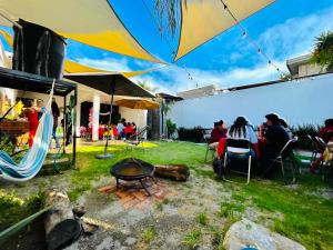 a group of people sitting in chairs under an umbrella at Loft Industrial Petfriendly in Tlaxcala de Xicohténcatl