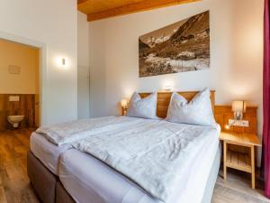 a bedroom with a large bed and a desk at Adlerblick in Werfenweng