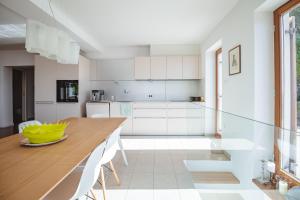 a kitchen with a wooden table and white cabinets at Piran Panorama Pool Villa in Piran