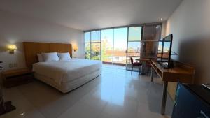 a bedroom with a bed and a desk and a television at Hotel Pascana Plaza in Santa Cruz de la Sierra +140 photos