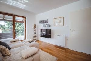 a white living room with a couch and a tv at Piran Panorama Pool Villa in Piran