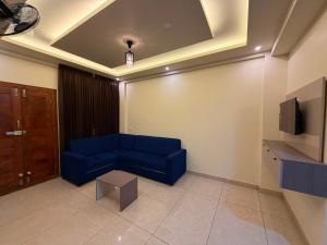 a living room with a blue couch and a tv at Hide Away in Padinjarathara