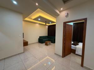 a hotel room with a bed and a green couch at Hide Away in Padinjarathara