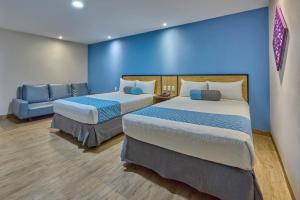 ein Zimmer mit zwei Betten und einer blauen Wand in der Unterkunft Continental Mexicano in Mexiko-Stadt