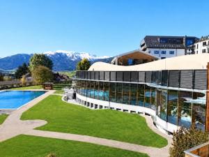a building with a pool and mountains in the background at Zederhaus in Mariapfarr