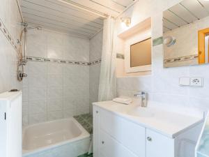 a white bathroom with a sink and a tub at Zederhaus in Mariapfarr +23 photos