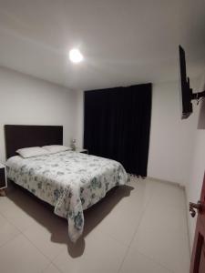 a bedroom with a bed and a black curtain at Alpha in Cajamarca