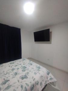 a bedroom with a bed and a flat screen tv at Alpha in Cajamarca