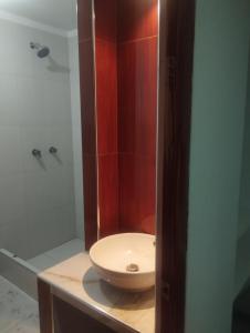 a bathroom with a white sink and a shower at Alpha in Cajamarca