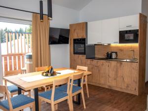 a kitchen and dining room with a wooden table and chairs at Bockblick Top 4 in Weisspriach